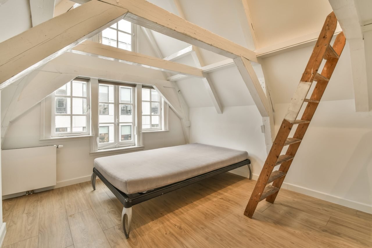 Empty new room with mansard windows Construction Company